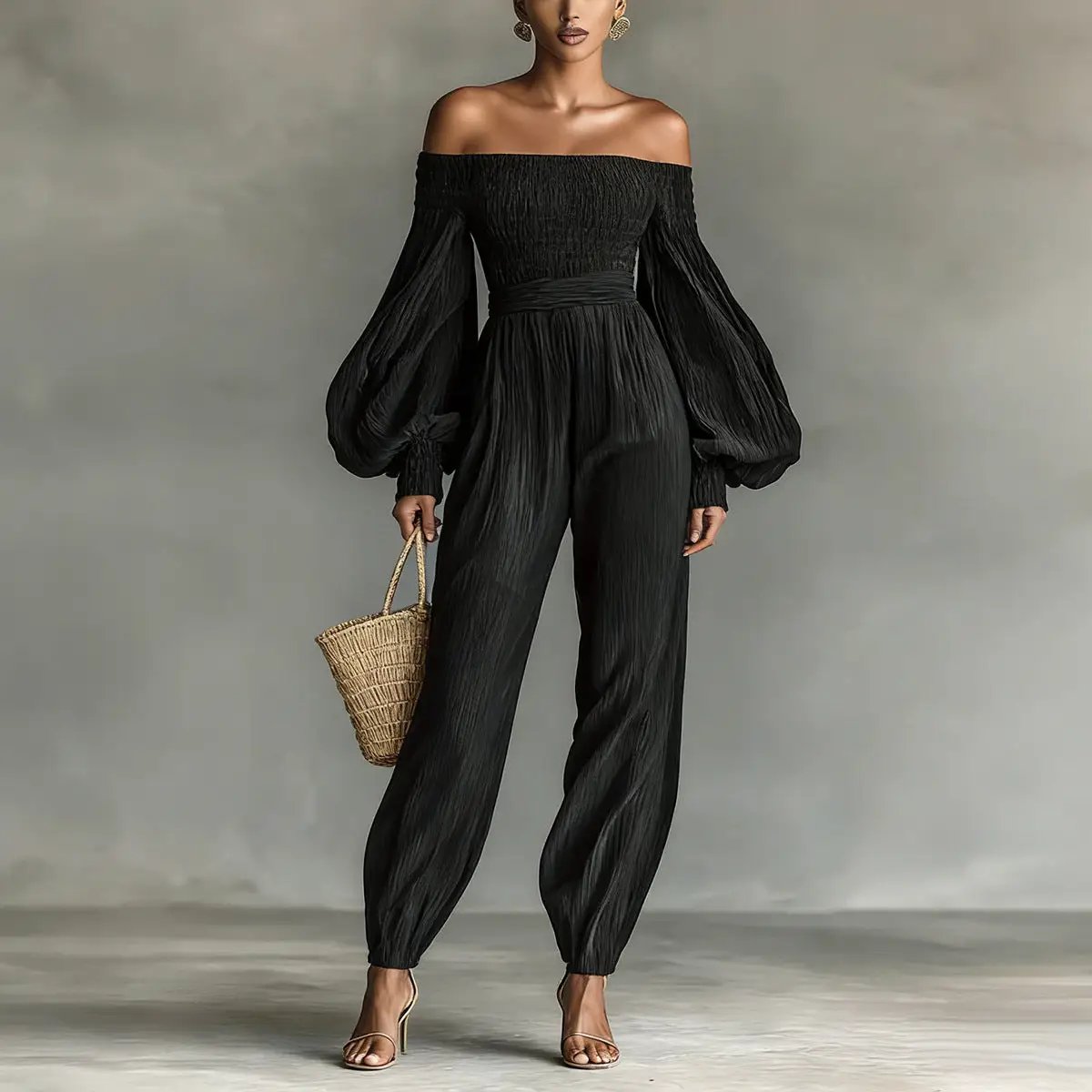 Off-shoulder black pleated jumpsuit with lantern sleeves and cinched waist.