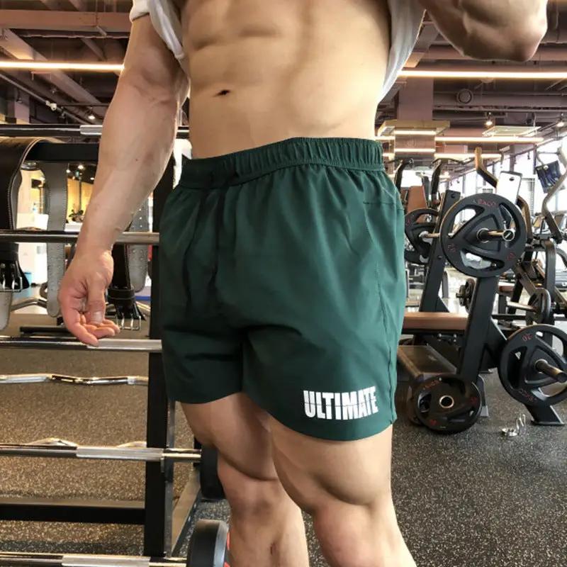 Men's green three-quarter quick-dry gym shorts with elastic waistband; Ultimate logo on leg