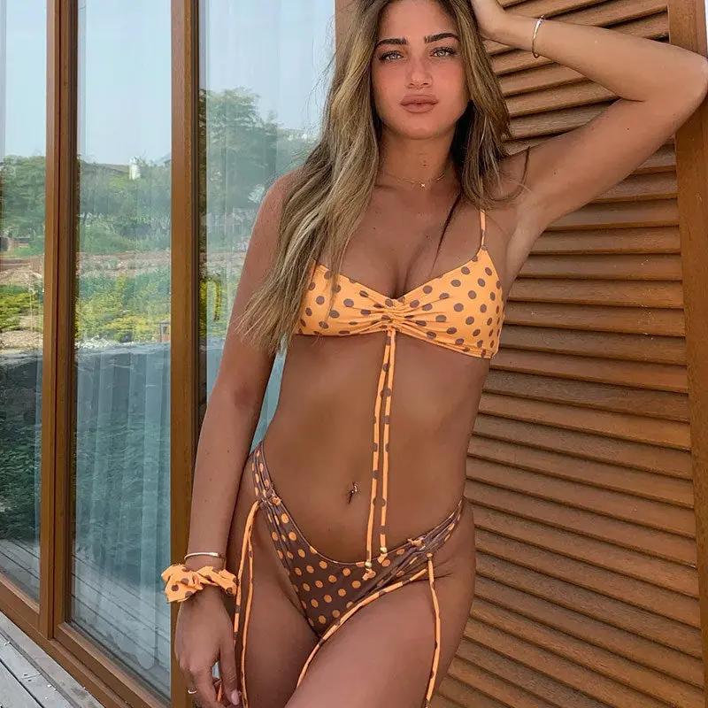 Two-piece women's swimsuit in orange polka-dot print with tie-front bandeau top and string-tie bottoms