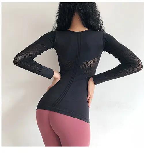 Women's black long-sleeve athletic top with mesh sleeves, seamless fit.