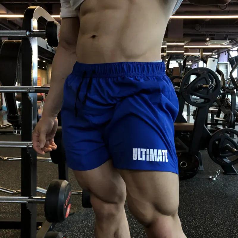 Men's blue quick-dry three-quarter gym shorts with elastic waistband and white ULTIMATE logo.