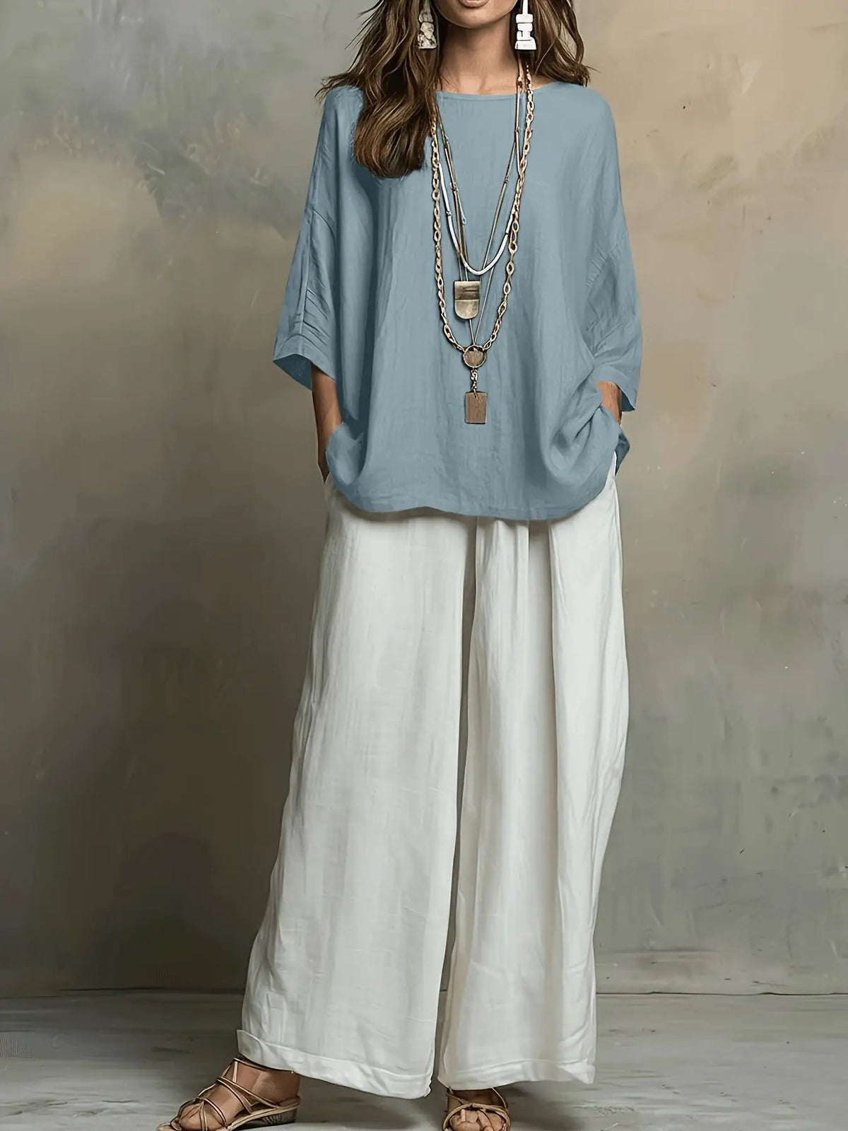 Bohemian style loose top and white wide-leg pants set in light blue with layered boho necklaces